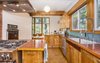 Modern home with Kitchen, Wood Counter, Metal Backsplashe, Wood Cabinet, Cork Floor, Ceiling Lighting, Track Lighting, Accent Lighting, Refrigerator, Wall Oven, Range, Pendant Lighting, Dishwasher, Undermount Sink, Range Hood, and Drop In Sink. Custom Birch Kitchen Photo 13 of Classic Mid Century Modern home for sale