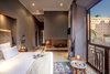 Modern home with Bedroom, Wall Lighting, Bed, Wardrobe, Pendant Lighting, Ceramic Tile Floor, Limestone Floor, Travertine Floor, Night Stands, Porcelain Tile Floor, Ceiling Lighting, Table Lighting, and Dresser. RoyalRiad Loft Suite Photo 5 of Riad Privilege Marrakech
