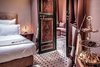 Modern home with Bedroom, Chair, Ceiling Lighting, Table Lighting, Bed, Limestone Floor, Travertine Floor, Porcelain Tile Floor, Night Stands, Slate Floor, Floor Lighting, Pendant Lighting, and Ceramic Tile Floor. Private exclusive suite at RoyalRiad Marrakech Photo 10 of Riad Privilege Marrakech