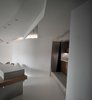 Modern home with Wood Counter, Ceiling Lighting, Concrete Floor, Wood Cabinet, Recessed Lighting, and Living Room. Lights and air conditioning vents are integrated into the ceiling and enrich its variation. Photo 5 of Fluid House