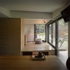 Modern home with Living Room, Ceiling Lighting, Accent Lighting, and Medium Hardwood Floor. A view from the dining room to the backyard through the guest room. Photo 12 of Simple House