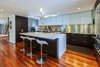 Modern home with Kitchen, White Cabinet, Engineered Quartz Counter, Dark Hardwood Floor, Metal Backsplashe, Ceiling Lighting, Medium Hardwood Floor, Refrigerator, Wall Oven, Recessed Lighting, Range, and Drop In Sink. Kitchen Photo 5 of Hemlock Hill