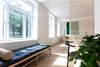 Modern home with Bedroom, Bench, Ceiling Lighting, Bed, Medium Hardwood Floor, Wall Lighting, and Chair. From bedroom til living room. Lots of natural lighting, even when the sliding door is partly closed. Daybed for relaxing moments after a hard and busy day at work. The work space is lightened up with LED on the wall/ceiling. Worktop desk is made of birch plywood with lots of storage. Photo 2 of Scandinavian/Japanese concept home in Oslo city center