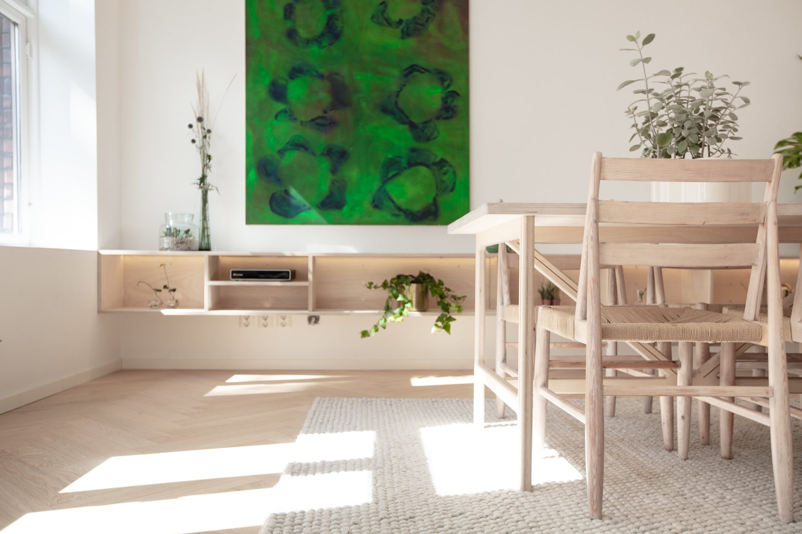 Living room: with oak herringbone floor, custom made 5 meter long tv-bench made of birch plywood. Treated with natural soap and osmo wax. Dining table also made of same materials with doubled 18 mm plywood glued together and added brass details. By creating an open space plan, the living room looks more spacious with the natural light added. LED lighting on the transition of wall/ceiling and on the tv bench.