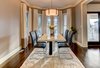 Modern home with Dining Room, Ceiling Lighting, Chair, Pendant Lighting, Table, Dark Hardwood Floor, and Rug Floor. The home has a masculine, monotone palette with sharp contrast. Photo 3 of Modern Infusions