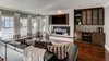 Modern home with Living Room, Gas Burning Fireplace, Ceiling Lighting, Ribbon Fireplace, Dark Hardwood Floor, Recessed Lighting, Media Cabinet, and Sofa. The living room focal wall features a recessed fireplace, custom surround, and new media cabinetry. Photo 4 of Modern Infusions