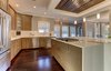 Modern home with Kitchen, Engineered Quartz Counter, Wood Cabinet, Pendant Lighting, Dark Hardwood Floor, Ceiling Lighting, Recessed Lighting, Refrigerator, Dishwasher, Range, Cooktops, and Drop In Sink. The new kitchen island creates plenty of room for the young couple to entertain. Photo of Modern Infusions