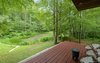 Modern home with House Building Type, Wood Siding Material, Concrete Siding Material, Stucco Siding Material, Outdoor, Side Yard, Woodland, Small Patio, Porch, Deck, Wood Patio, Porch, Deck, Garden, Trees, and Shrubs. 'Pond House' - Porch View Photo 6 of Mountain House Modern