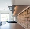 Modern home with Kitchen, Engineered Quartz Counter, Porcelain Tile Floor, White Cabinet, Brick Backsplashe, Recessed Lighting, Range Hood, and Range. LED Lighting and GFI electrical strips are hidden underneath cabinets for a clean look. Photo 4 of Vegas Luxe