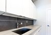 Modern home with Laundry Room, White Cabinet, Quartzite Counter, and Side-by-Side. Macauba Quartzite runs the length of the Laundry Room counter with stacked porcelain slate from the floor to ceiling Photo 12 of Vegas Luxe