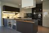 Modern home with Kitchen, Wood Cabinet, Terrazzo Floor, Engineered Quartz Counter, Wall Lighting, Ceiling Lighting, Refrigerator, Wall Oven, Undermount Sink, Range Hood, Microwave, and Cooktops. Kitchen from Dada Italy Photo 2 of The house ISIS