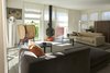 Modern home with Living Room, Chair, Sofa, Coffee Tables, Storage, Bar, Floor Lighting, Terrazzo Floor, Wood Burning Fireplace, and Hanging Fireplace. Living room Photo 4 of The house ISIS