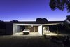 Modern home with Outdoor, Front Yard, Woodland, Field, Shrubs, Garden, Hardscapes, Boulders, Walkways, Grass, Large Patio, Porch, Deck, Gardens, Concrete Patio, Porch, Deck, and Metal Patio, Porch, Deck. East Elevation - Utility zone for 'The Ride' from mishacks' modular design system. (Nothing sweeter than the rumble of a Thunderbird docking in the twilight). Photo 3 of 01 White Shack.