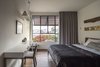 Modern home with Bed, Pendant Lighting, Wall Lighting, Table Lighting, Medium Hardwood Floor, Kids Room, Neutral Gender, Bedroom Room Type, and Teen Age. The Charm Townhouse - First floor bedrooms Photo 16 of The Charm Townhouse