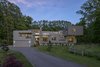 Modern home with Kitchen, Wood Cabinet, Granite Counter, Stone Counter, Concrete Floor, Medium Hardwood Floor, Recessed Lighting, Refrigerator, Cooktops, Wall Oven, Range, Microwave, Beverage Center, and Drop In Sink. Dusk exterior Photo of The Milton House