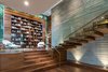 Modern home with Staircase, Wood Tread, and Glass Railing. A magnificent floating staircase leads to the second story, featuring an enlarged landing that serves as a formal library with a a 15-foot high built-in bookcase. Photo 4 of The Quintessence of Luxe California Living in Pacific Palisades