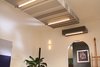 Modern home with Living Room, Ceiling Lighting, and Wall Lighting. Soffit over rear end of main multi-mode room with kitchen beyond Photo 11 of Facade/Fasad