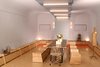 Modern home with Dining Room, Bench, Table, Storage, Chair, Lamps, Wall Lighting, Ceiling Lighting, Carpet Floor, and Plywood Floor. Main multi-mode room looking toward entry set for large dinner party with custom tables and benches Photo 18 of Facade/Fasad