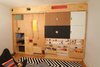 Modern home with Kids Room, Playroom Room Type, Chair, Bookcase, Shelves, Storage, Boy Gender, Pre-Teen Age, Medium Hardwood Floor, and Neutral Gender. Step-storage and moving divider panel as seen from playroom with storage and usable surfaces Photo 3 of LO Residence Playroom/Bedroom