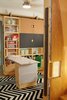 Modern home with Kids Room, Playroom Room Type, Medium Hardwood Floor, Storage, Shelves, Boy Gender, Neutral Gender, and Pre-Teen Age. Moving storage unit in playroom with work table (down) Photo 13 of LO Residence Playroom/Bedroom