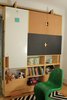 Modern home with Kids Room, Playroom Room Type, Medium Hardwood Floor, Shelves, Storage, Pre-Teen Age, Neutral Gender, and Boy Gender. Closeup moving storage unit with work table (up) and usable surfaces on doors: dry erase, cork, and chalkboards Photo 14 of LO Residence Playroom/Bedroom