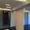 Modern home with Living Room, Ceiling Lighting, Accent Lighting, and Dark Hardwood Floor. Living room looking North with room divider panels and stone entry beyond Photo 2 of MB Residence (Nearing Completion)