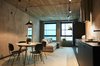 Modern home with Living Room, Concrete Floor, Chair, Ceiling Lighting, Table Lighting, Wall Lighting, Floor Lighting, Lamps, Storage, Desk, and Coffee Tables. The living area at one of the apartments Photo 9 of HUT