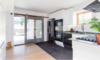 Modern home with Kitchen, White Cabinet, Light Hardwood Floor, Ceramic Tile Backsplashe, Refrigerator, Ceiling Lighting, Recessed Lighting, Microwave, Wall Oven, Dishwasher, Cooktops, Undermount Sink, Range Hood, and Drop In Sink. Kitchen Photo 5 of East Pender home