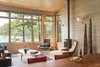 Modern home with Living Room, Chair, Sofa, End Tables, Coffee Tables, Wall Lighting, Light Hardwood Floor, and Gas Burning Fireplace. The living room gives the feeling that you are sitting directly above the water. Photo 4 of Fontana Lake House