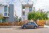 Modern home with Outdoor, Front Yard, Side Yard, Trees, Hardscapes, Grass, Small Patio, Porch, Deck, Horizontal Fences, Wall, Metal Fences, Wall, Walkways, Wood Patio, Porch, Deck, and Wire Fences, Wall. View from Abbott St. West Elevation Photo 5 of Three on Abbott