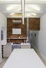Modern home with Kitchen, Engineered Quartz Counter, Wood Cabinet, Light Hardwood Floor, Ceiling Lighting, Pendant Lighting, Brick Backsplashe, Recessed Lighting, Accent Lighting, Wall Oven, Cooktops, Range, Range Hood, and Undermount Sink. Kitchen (Night) Photo 15 of Curtain Cottage
