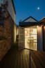 Modern home with Hardscapes, Raised Planters, Small Patio, Porch, Deck, Back Yard, Decking Patio, Porch, Deck, Planters Patio, Porch, Deck, Wood Patio, Porch, Deck, Hanging Lighting, Doors, Metal, Swing Door Type, and Exterior. Courtyard (Night) Photo 18 of Curtain Cottage