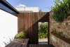 Modern home with Back Yard, Small Patio, Porch, Deck, Gardens, Raised Planters, Hardscapes, Wood Patio, Porch, Deck, Decking Patio, Porch, Deck, Wood Fences, Wall, and Outdoor. Rear wall of courtyard Photo 19 of Curtain Cottage