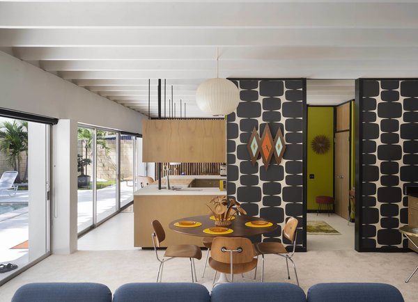 A Herman Miller chicklet sofa (foreground) and a Saarinen by Knoll dining table with Eames' DCM plywood chairs are clearly at home in this authentic midcentury modern abode.