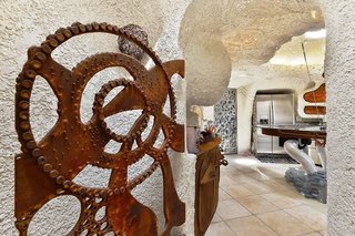 Curvy walls undulate throughout the home, making a rectangular refrigerator look quite out of place. 
