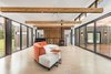 Modern home with Living Room, Sofa, End Tables, Ceiling Lighting, Recessed Lighting, Cork Floor, Corner Fireplace, Accent Lighting, and Track Lighting. The main living space features north and south window walls. The flooring is cork. Photo 5 of Copperwood