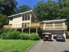 Modern home with Attached Garage Room Type, Outdoor, Wood Patio, Porch, Deck, Front Yard, Large Patio, Porch, Deck, Rooftop, Horizontal Fences, Wall, and Wood Fences, Wall. A full front view from the driveway Photo 4 of The Gugs House