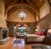 Modern home with Bedroom, Bed, Night Stands, Medium Hardwood Floor, Chair, and Ceiling Lighting. Owner Suite Photo 4 of Ultimate Western Farmhouse