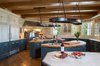Modern home with Kitchen, Wood Counter, White Cabinet, Ceiling Lighting, Medium Hardwood Floor, Range, Refrigerator, Dishwasher, Range Hood, Microwave, and Drop In Sink. Gourmet Kitchen with Commercial Grade Appliances Photo 3 of Ultimate Western Farmhouse