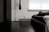 Modern home with Bedroom, Dark Hardwood Floor, and Bed. "I studied Product Design at National Institute of Design in India, which is often regarded as Eames school, founded by the designer couple Charles & Ray Eames. The space I wanted to live in wouldn’t have been complete without a few of Eames' classics. Quite contrary to where one usually showcase the Eames bird on their shelves, it sits along my bedside waking me up to inspiring mornings every day”. Photo 6 of Living in Monochrome, far away from Nordic lands