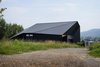 Modern home with Outdoor, Boulders, and Slope. Architecture and the landscape. The northern facade mostly consists of a roof slope falling to the plot border - the house’s wall is low and closed here. Supplementary rooms are at the northern side. Photo 3 of BLACK ROCK