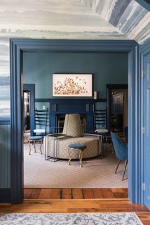 Off the foyer, what was originally the check-in area for guests was turned into a swanky lounge, featuring a round "sociable sofa," upholstered in Kravet Verbier Diamond fabric in Leaf/Teal.