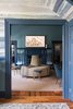 Modern home with Living Room, Chair, Bench, Medium Hardwood Floor, Rug Floor, Stools, and Standard Layout Fireplace. Off the foyer, what was originally the check-in area for guests was turned into a swanky lounge, featuring a round "sociable sofa," upholstered in Kravet Verbier Diamond fabric in Leaf/Teal. Photo 4 of The Clifton