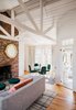 Modern home with Living Room, Table, Chair, Standard Layout Fireplace, Stools, Medium Hardwood Floor, and Rug Floor. Inside, large windows and vaulted ceilings create a bright and cheery atmosphere. Photo 12 of The Clifton