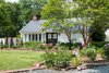 Modern home with Exterior, Metal Roof Material, Wood Siding Material, Gable RoofLine, and House Building Type. The original carriage house was transformed into a bridal suite that now has three guest rooms. Photo 11 of The Clifton