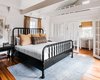 Modern home with Bedroom, Wall Lighting, Bed, Medium Hardwood Floor, and Rug Floor. Inside the cottage are two bedrooms that have been updated with crisp white paint, new linens, and light fixtures. Photo 14 of The Clifton