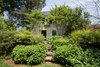 Modern home with Exterior, Metal Roof Material, and Gable RoofLine. The neighboring garden cottage originally was Randolph’s law office. This space shares a garden with the old carriage house. Photo 13 of The Clifton