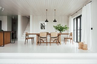 In the dining room, black light fixtures by Brokis visually connect to other black architectural details, like the window frames and light switches.