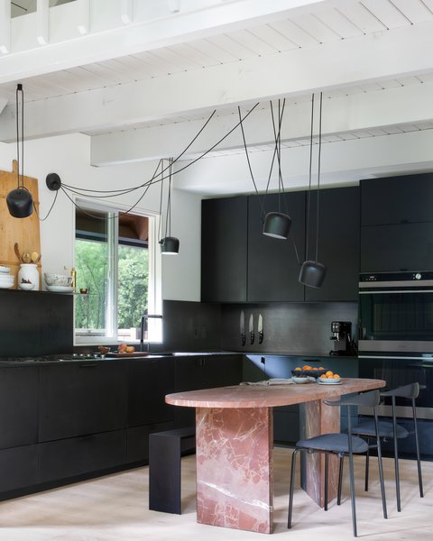 The blush-colored Rojo Alicante marble table in the center of the kitchen doubles as a dining table and kitchen island. A Craiglist score for $200, the table is another kitchen hack conceived by the architects. “It was really a diamond in the rough. Originally, it was a rectangle shape, in a weird ’90s, Italian kind of style, covered in a thick, resin-like finish that made it look almost orange,” says Daniel. The table was honed down to soften its color, and its top was reshaped with rounded corners.