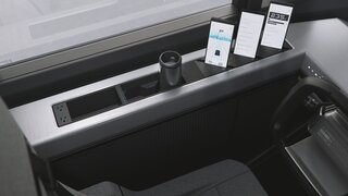 To the left of the driver’s seat, an inset panel holds devices at the ready while on the road.